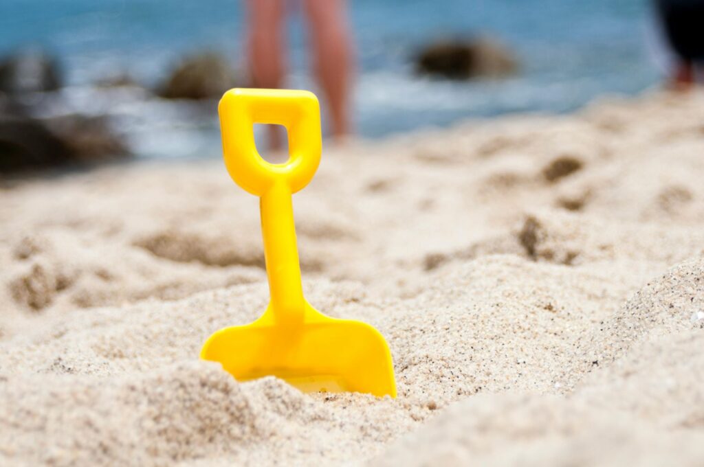 a yellow shovel in the sand