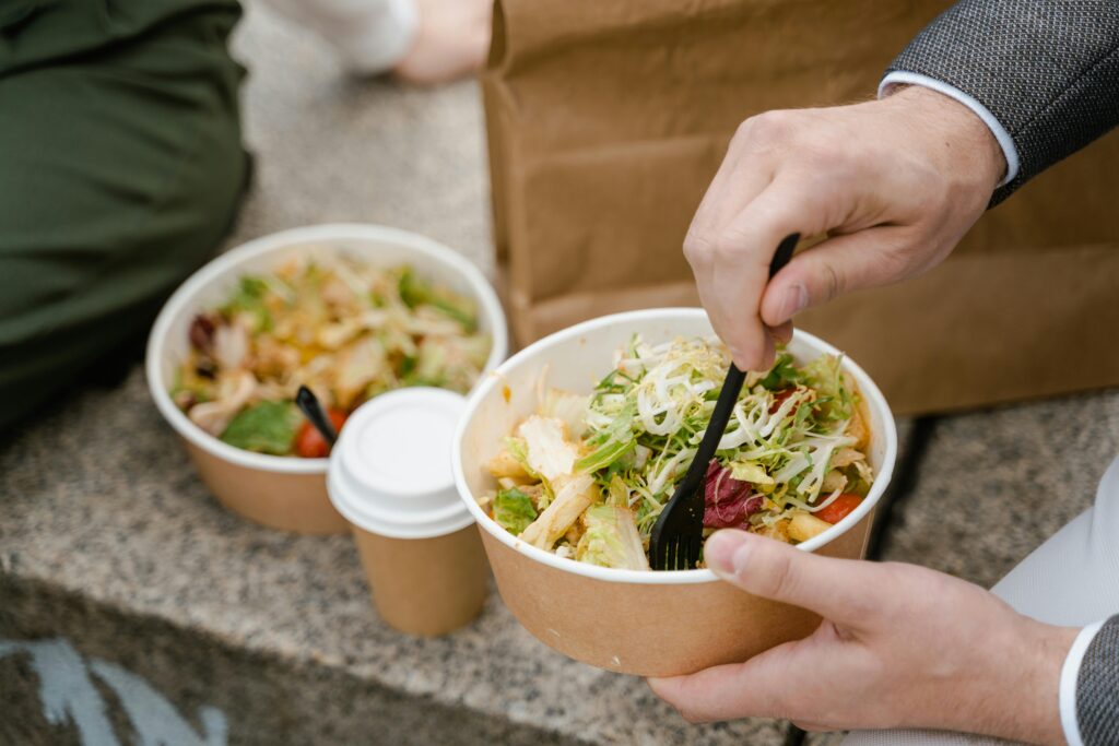 a person holding a bowl of salad