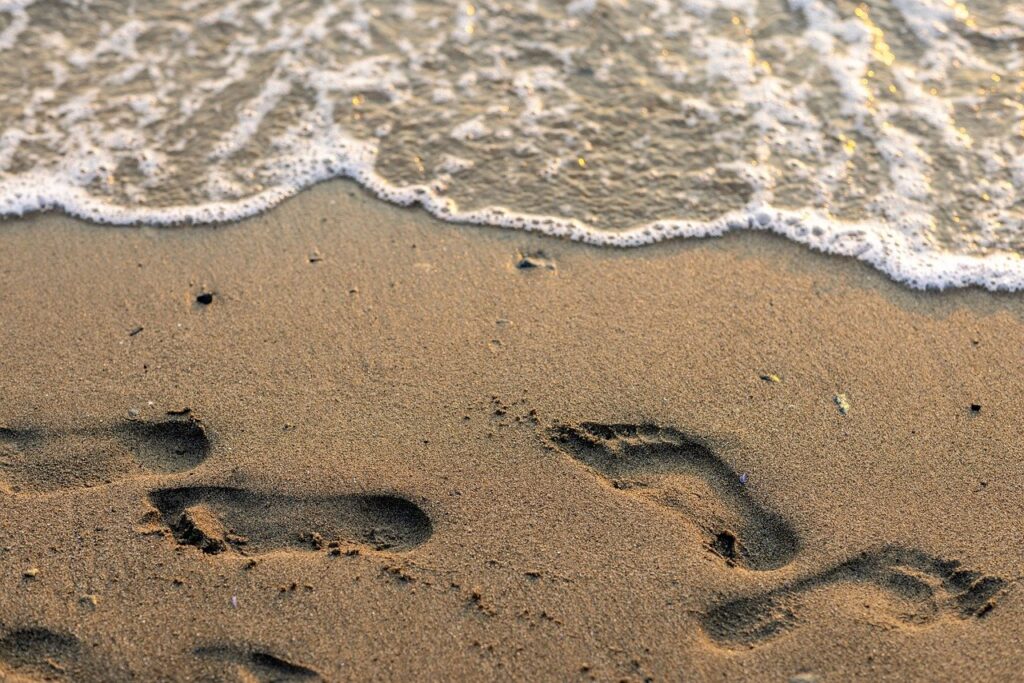 a seashore with foot prints in the sand